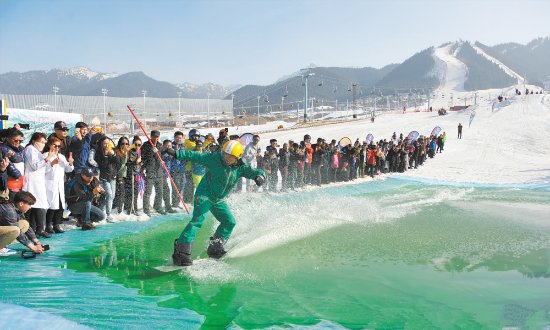 上图为3月24日，在丝绸之路国际度假区滑雪场，滑雪爱好者在体验雪地滑水。