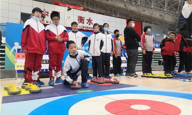 小学生运动员在进行陆地冰壶比赛