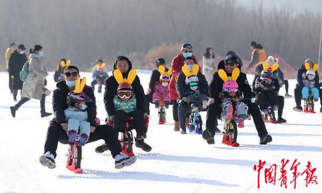 北京平谷渔阳国际滑雪场，家长们带着孩子骑着滑步车滑雪