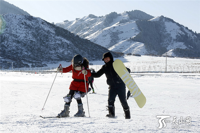 在白云国际滑雪场内，一位初学者在同伴的搀扶下学习滑雪。